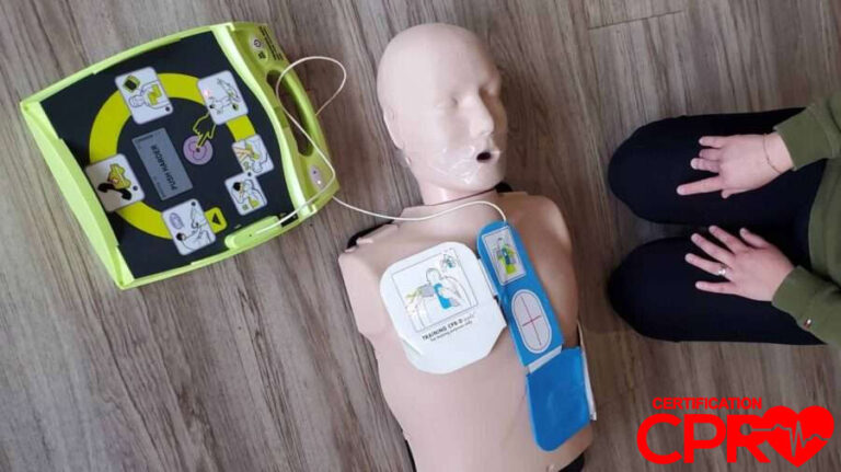 CPR training mannequin with AED practice pads and defibrillator.