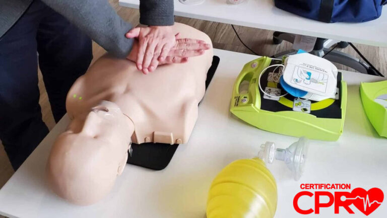 AED trainer connected to a CPR mannequin during hands-on class practice.