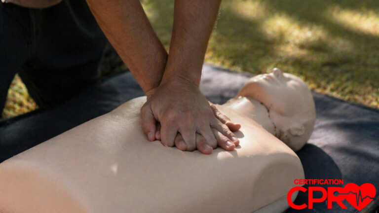Person performing hands-only CPR on a mannequin outdoors in Tampa.