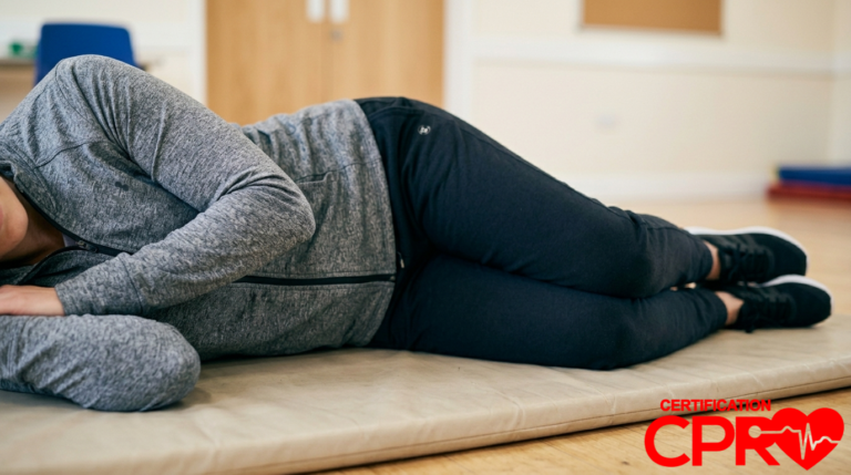 Person lying on side demonstrating recovery position for CPR and first aid training.